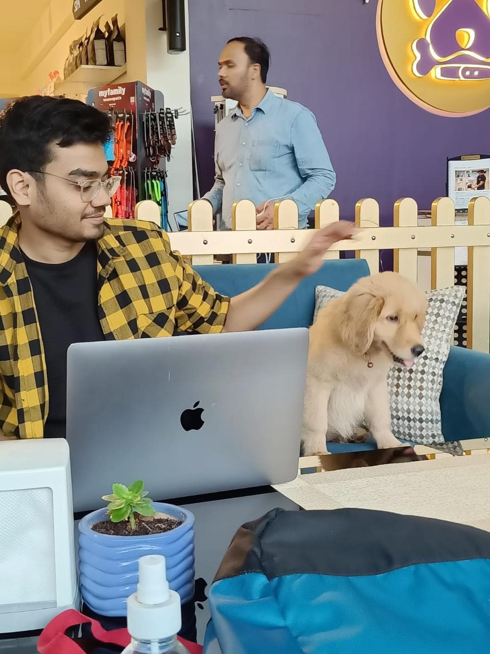 Kshitiz working on a laptop with a dog nearby